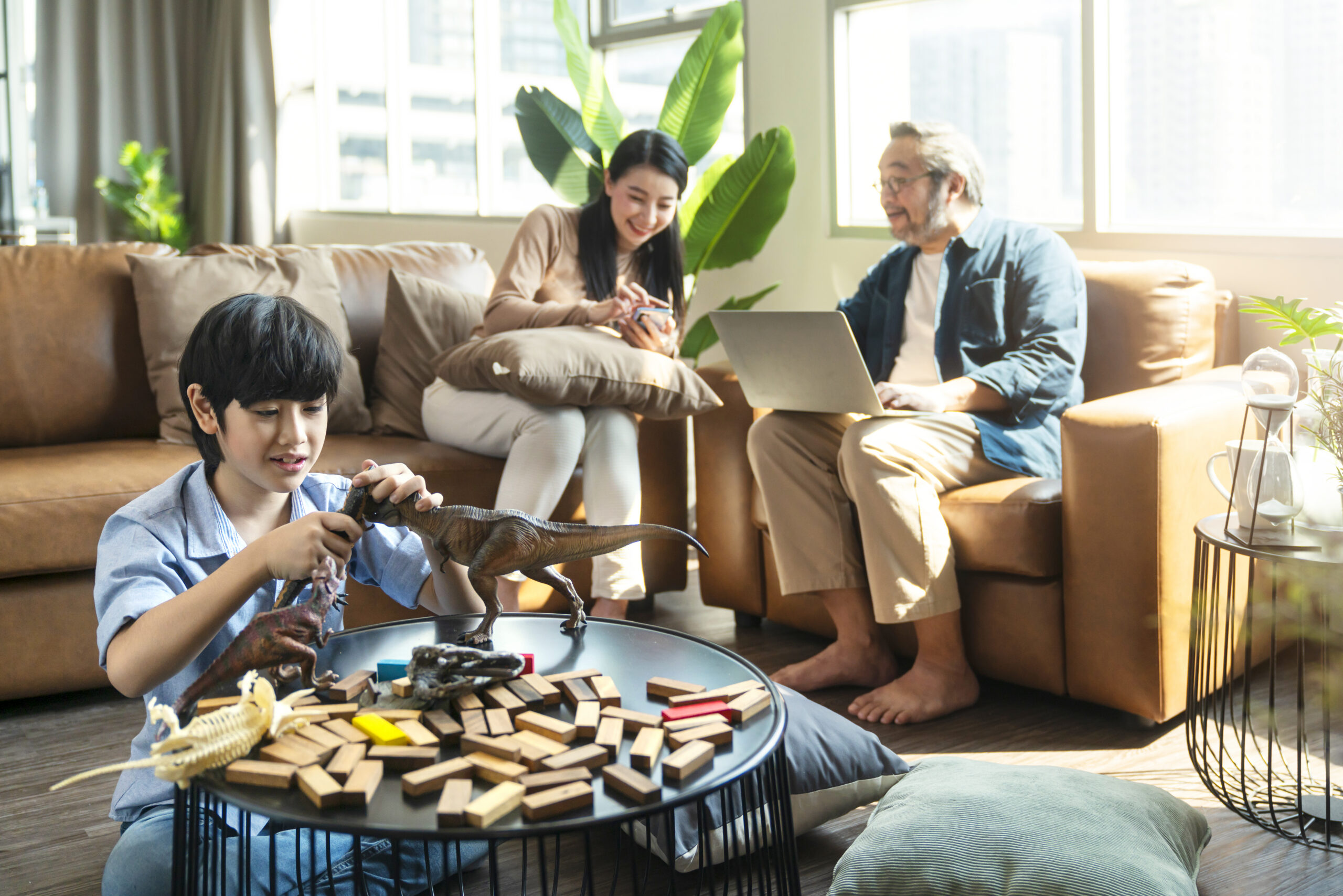 happiness-son-kid-playing-while-parents-relaxing-sofa-home-together-smiling-active-boy-entertaining-with-toy-dinosaurs-floor-happy-family-spending-time-together-living-room-weekend